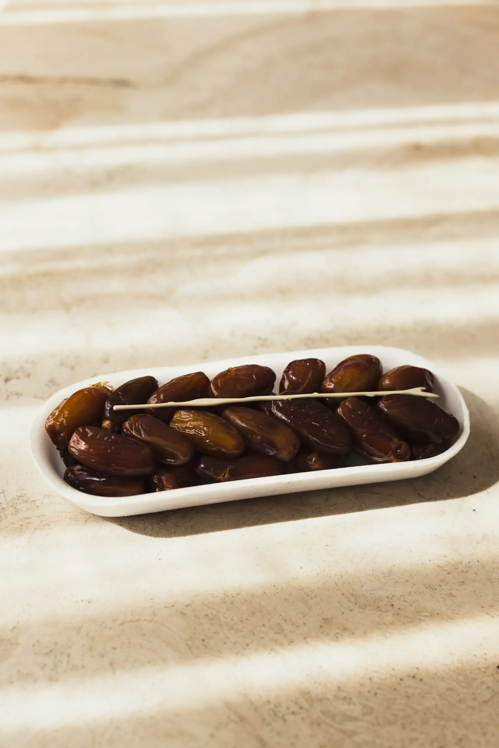 Delicious dates in a white dish, perfect for snacking."